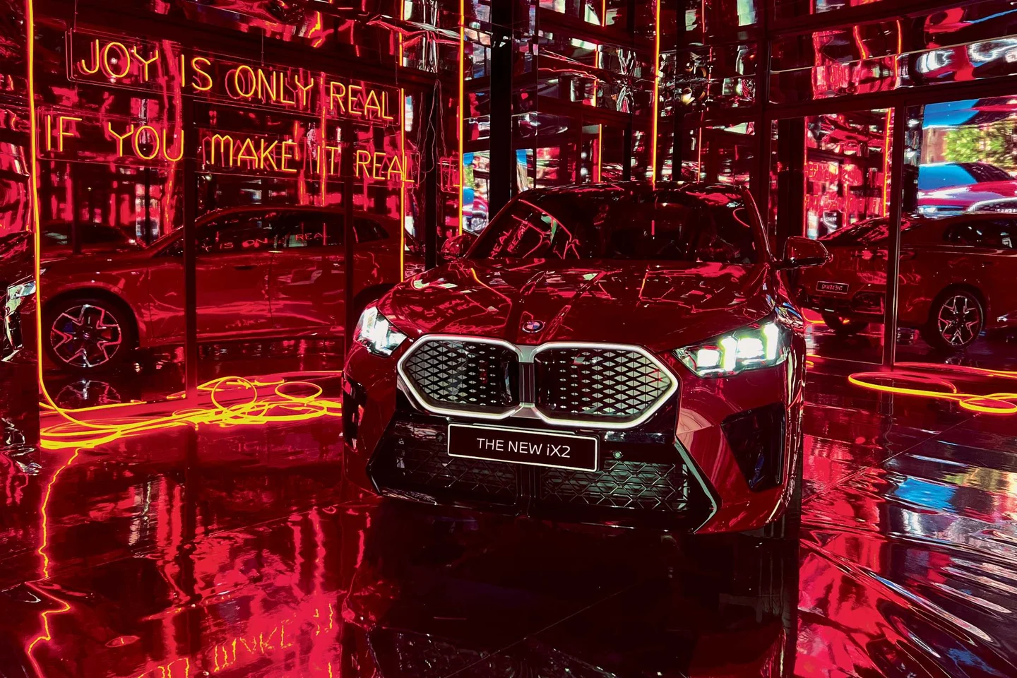 The reflective red BMW iX2 installation environment from BMW's Make It Real campaign associated with Lil Miquela.